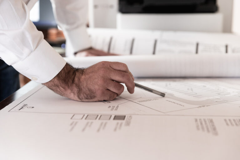 Man leaning over drafting table with pen in hand