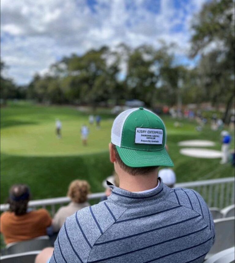 man with baseball cap looking out onto golf course